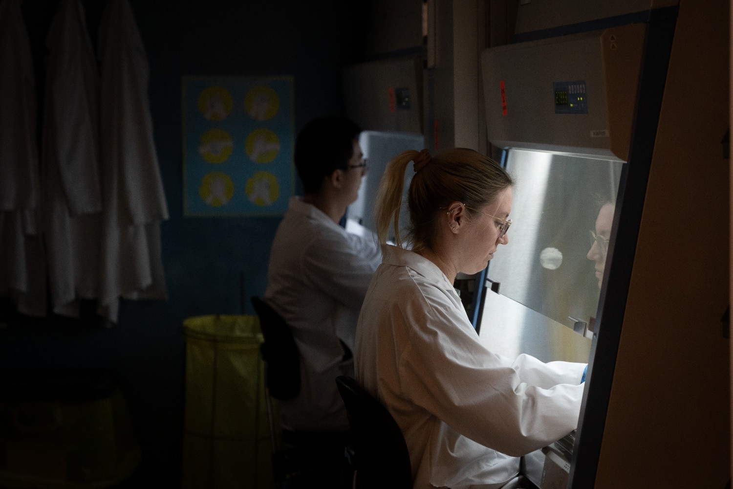 SRI staff pipetting at a fume hood in the lab.